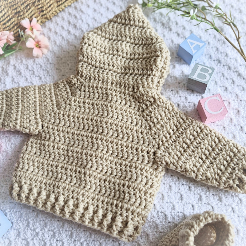 Handmade Crochet Baby Hooded Cardigan – Newborn to 12 Months – Baby Toddler Cardigans crafted in soft acrylic yarn and available in multiple colours by Twisted by the Sea.