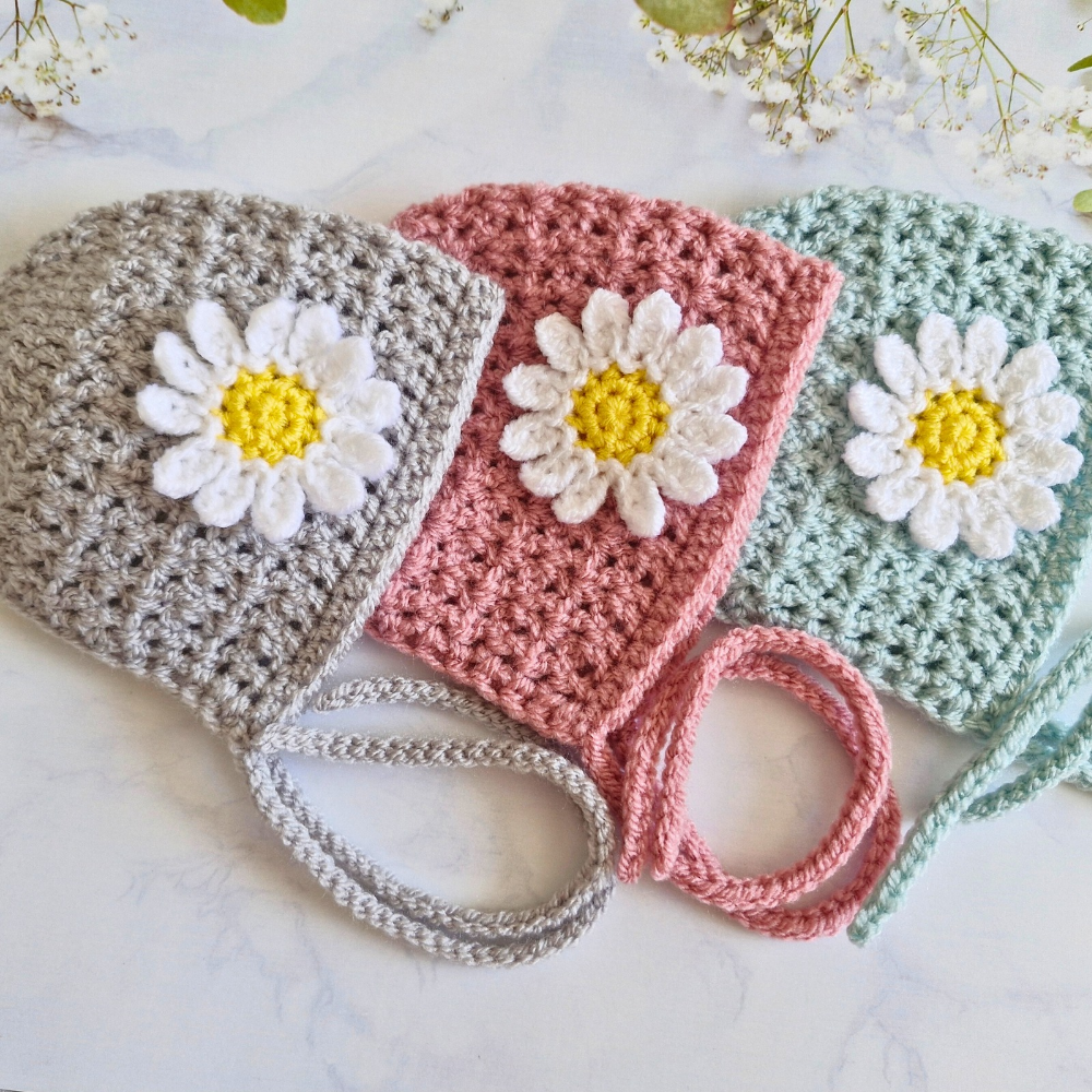 Handmade Handmade Crochet Daisy Baby Bonnet – Newborn to 12 Months – Beanie Hat crafted in soft acrylic yarn and available in multiple colours by Twisted by the Sea.