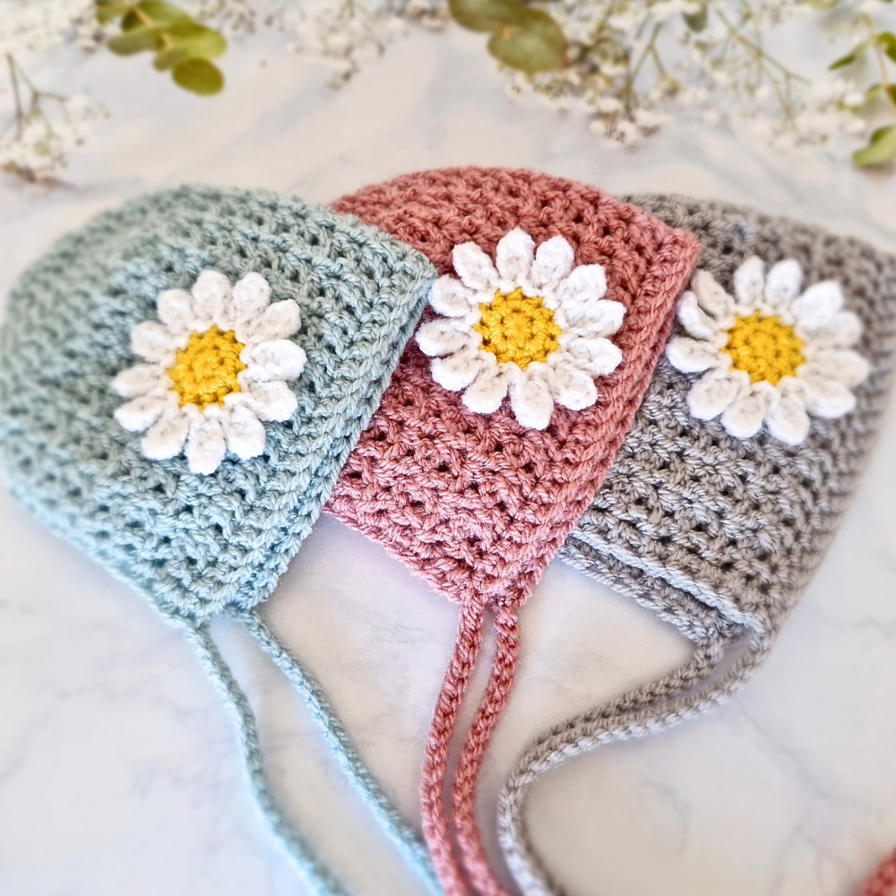 Handmade Handmade Crochet Daisy Baby Bonnet – Newborn to 12 Months – Beanie Hat crafted in soft acrylic yarn and available in multiple colours by Twisted by the Sea.