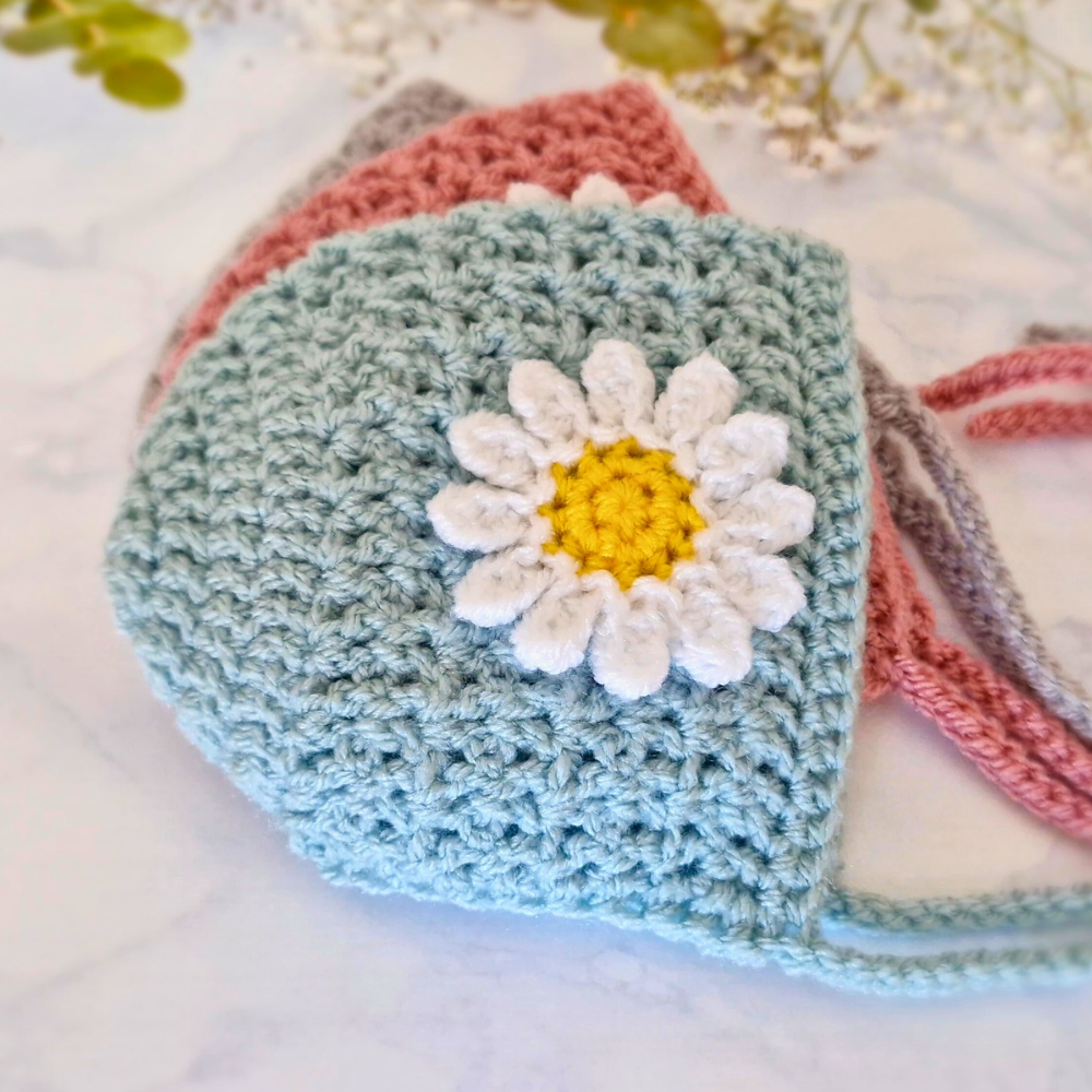 Handmade Handmade Crochet Daisy Baby Bonnet – Newborn to 12 Months – Beanie Hat crafted in soft acrylic yarn and available in multiple colours by Twisted by the Sea.