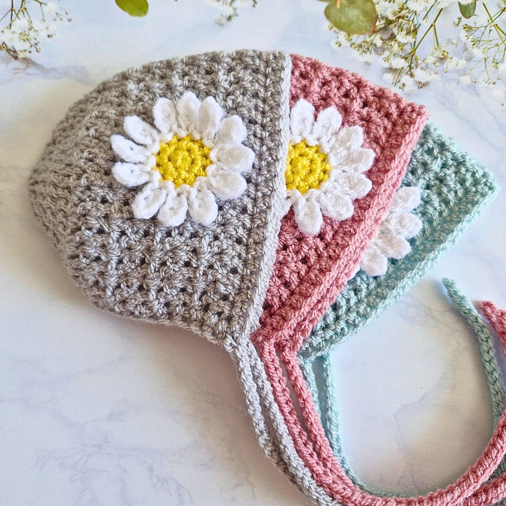 Handmade Handmade Crochet Daisy Baby Bonnet – Newborn to 12 Months – Beanie Hat crafted in soft acrylic yarn and available in multiple colours by Twisted by the Sea.