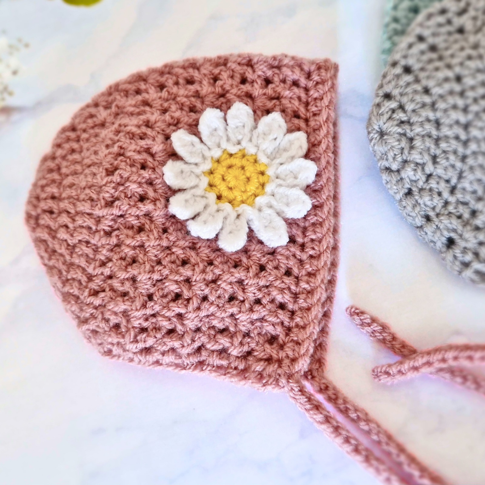 Handmade Handmade Crochet Daisy Baby Bonnet – Newborn to 12 Months – Beanie Hat crafted in soft acrylic yarn and available in multiple colours by Twisted by the Sea.