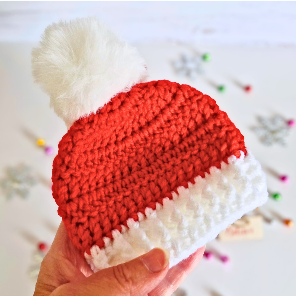 Handmade Handmade Christmas Baby Hat – Red & White Pom Pom Beanie (Newborn to 6 Months) – Pom Pom Hat crafted in soft acrylic yarn and available in multiple colours by Twisted by the Sea.