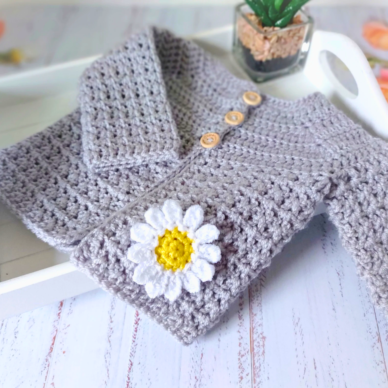 Handmade Crochet Daisy Baby Cardigan – Handmade in sizes 12 to 24 Months – Baby Toddler Cardigans crafted in soft acrylic yarn and available in multiple colours by Twisted by the Sea.