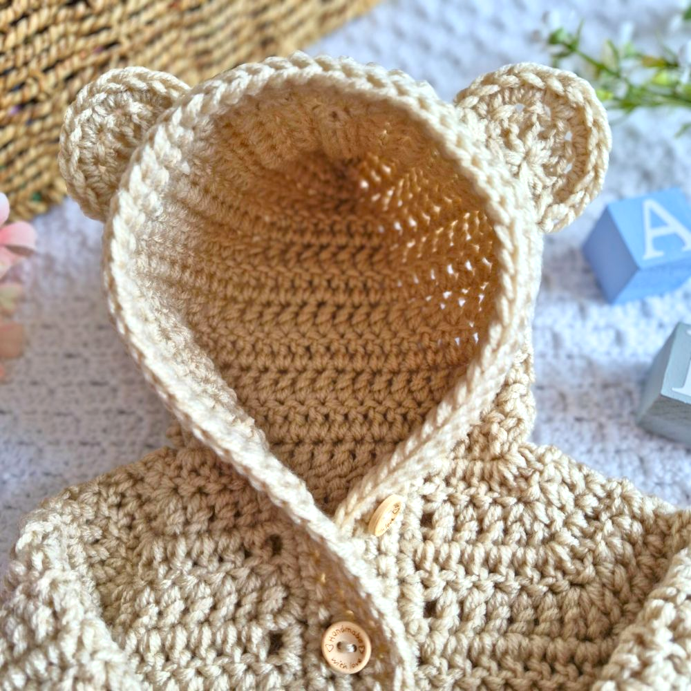 Handmade Crochet Baby Hooded Cardigan – Newborn to 12 Months – Baby Toddler Cardigans crafted in soft acrylic yarn and available in multiple colours by Twisted by the Sea.