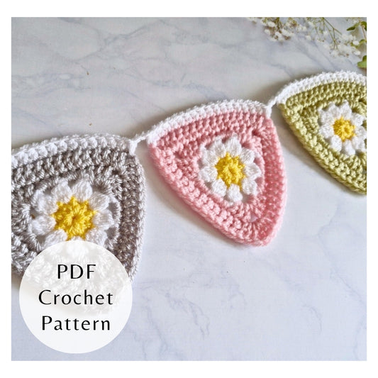 Crocheted flower patterns with a PDF crochet pattern label on a marble surface.