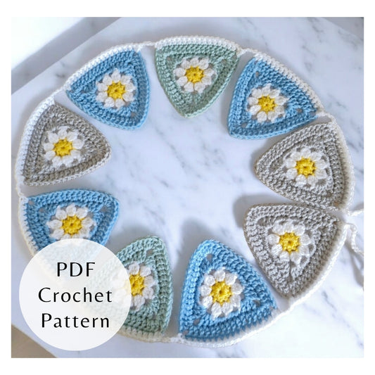 Handmade daisy granny triangle bunting in a colorful garland. A beginner friendly stash buster PDF crochet pattern by Twisted by the Sea.