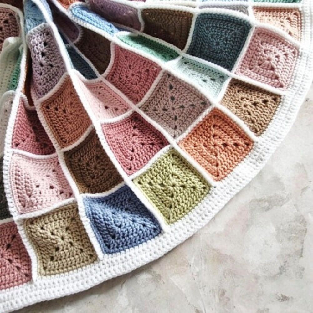 Stash busting crochet blanket joined in white with a neat border