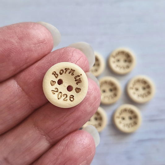 Handmade Born In 2026 Wooden Buttons – 15mm Natural Craft Buttons – Pack of 10, for Sewing, Knitting, Crochet – Buttons crafted in soft acrylic yarn and available in multiple colours by Twisted by the Sea.