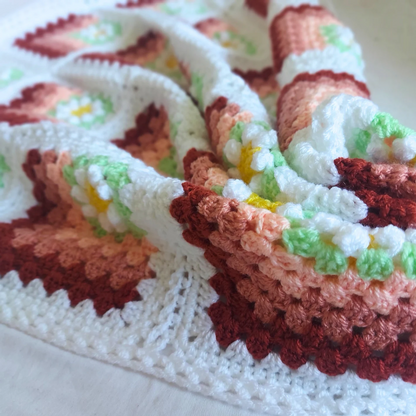 Colorful crocheted blanket with a pattern on a white background