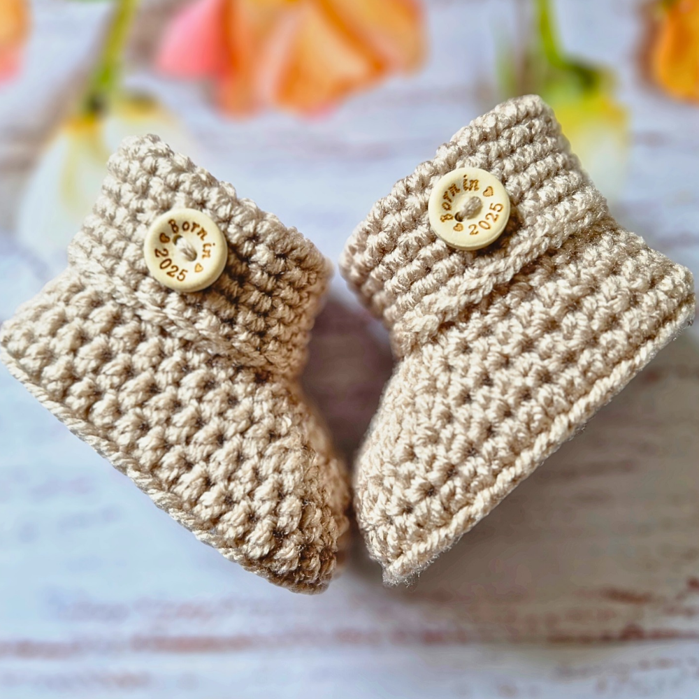 Handmade ‘Born in 2026’ Crochet Baby Booties – Handmade Newborn Gift or Pregnancy Reveal – Baby Booties crafted in soft acrylic yarn and available in multiple colours by Twisted by the Sea.