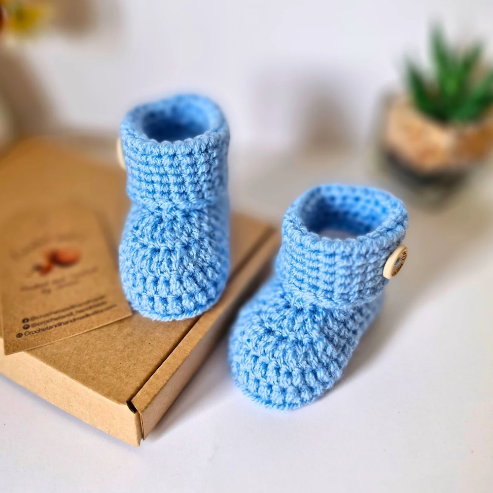 Handmade ‘Born in 2026’ Crochet Baby Booties – Handmade Newborn Gift or Pregnancy Reveal – Baby Booties crafted in soft acrylic yarn and available in multiple colours by Twisted by the Sea.