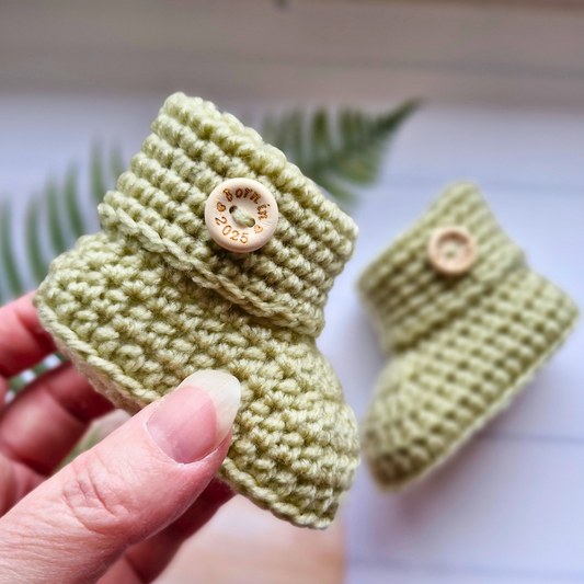 Handmade Born in 2025 Baby Booties – Handmade Crochet Gift for Newborns & Infants – Baby Booties crafted in soft acrylic yarn and available in multiple colours by Twisted by the Sea.