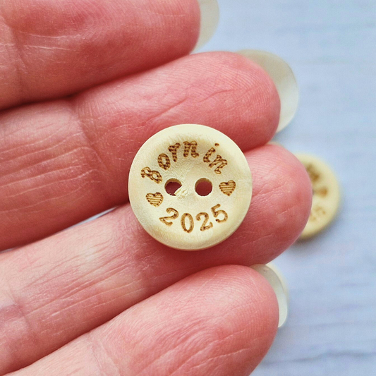 Handmade Born In 2025 Wooden Buttons – 15mm Natural Craft Buttons – Pack of 10, for Sewing, Knitting, Crochet – Buttons crafted in soft acrylic yarn and available in multiple colours by Twisted by the Sea.