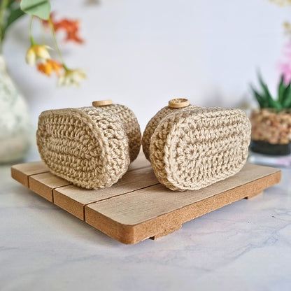 Sole view of a pair of parchment coloured crochet baby booties