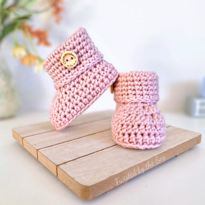 Pink crochet baby booties with 'handmade with love' wooden buttons. Available in multiple colours and szes newborn, 0-3 and 3-6 months. 