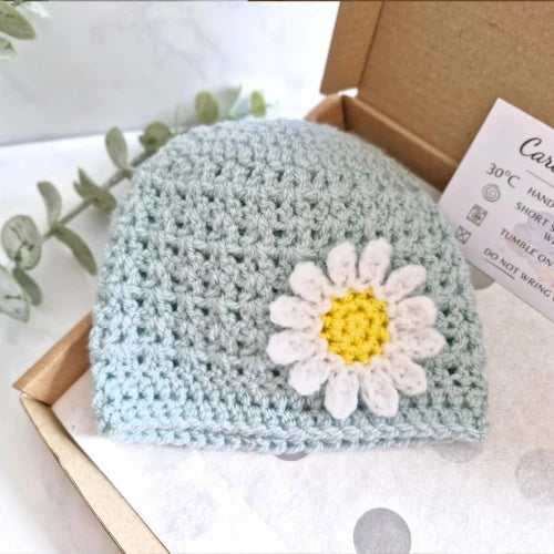 Crochet baby beanie hat in duck egg blue with a white and yellow daisy flower detail