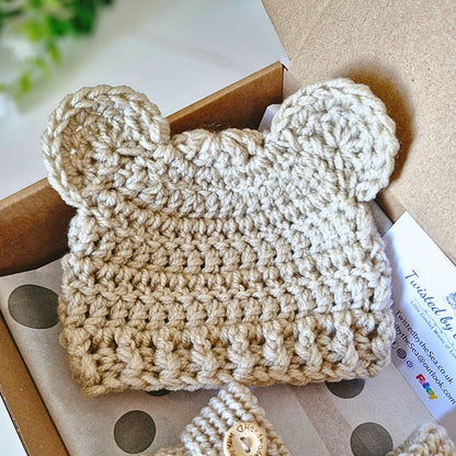 Beige crochet baby hat with ears on a box