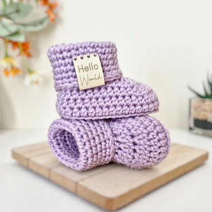 Newborn pair of heather coloured crochet baby booties stacked on each other