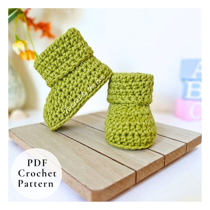 Green crochet baby booties on a wooden surface with 'PDF Crochet Pattern' text.