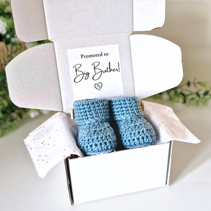 Blue baby booties in a box with a 'Promoted to Big Brother!' card.