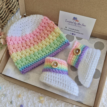 Rainbow baby gift set with crochet beanie hat and booties, handmade for newborns, displayed in a letterbox-friendly box with a branded Twisted by the Sea card