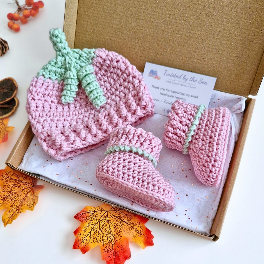 Crocheted baby hat and booties summerween set in a box with autumn leaves on a white background