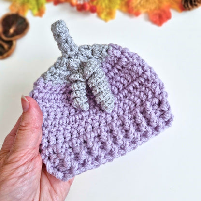 Hand holding a crocheted summerween hat in Twilight mist (heather and silver shades)