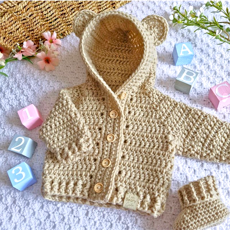 Handmade Crochet Baby Hooded Cardigan – Newborn to 12 Months – Baby Toddler Cardigans crafted in soft acrylic yarn and available in multiple colours by Twisted by the Sea.