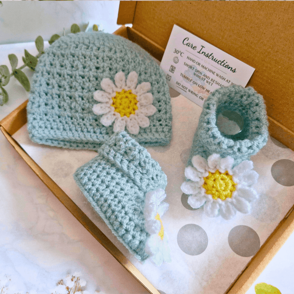 ​Handcrafted duck egg blue crochet baby set featuring a daisy beanie hat and matching booties on a gift box - Twisted by the Sea