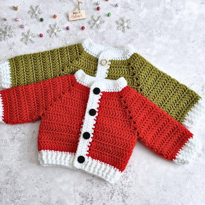 Two crocheted baby cardigans laid flat on a light textured surface, featuring a red and white cardigan wth black buttons, and a mistletoe green and white trim with wooden buttons. Small decorative snowflakes and beads are scattered around it.